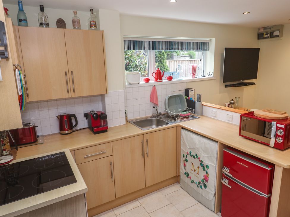 A kitchen with appliances and furniture at Mini Mena in St Austell