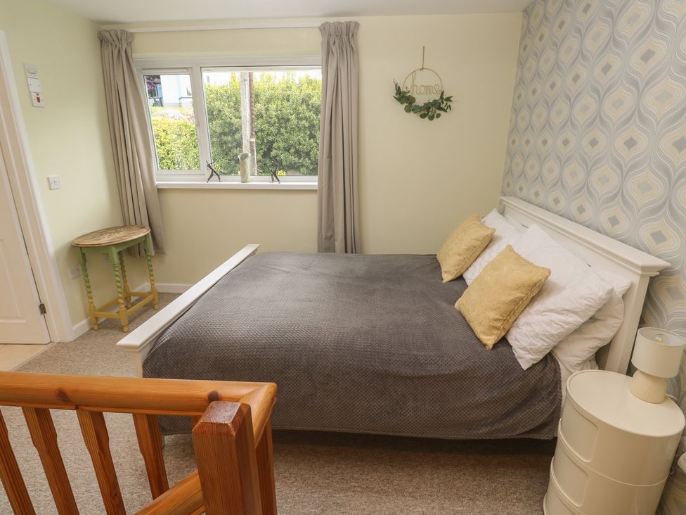 A bedroom with a bed and a small table at Mini Mena in St Austell