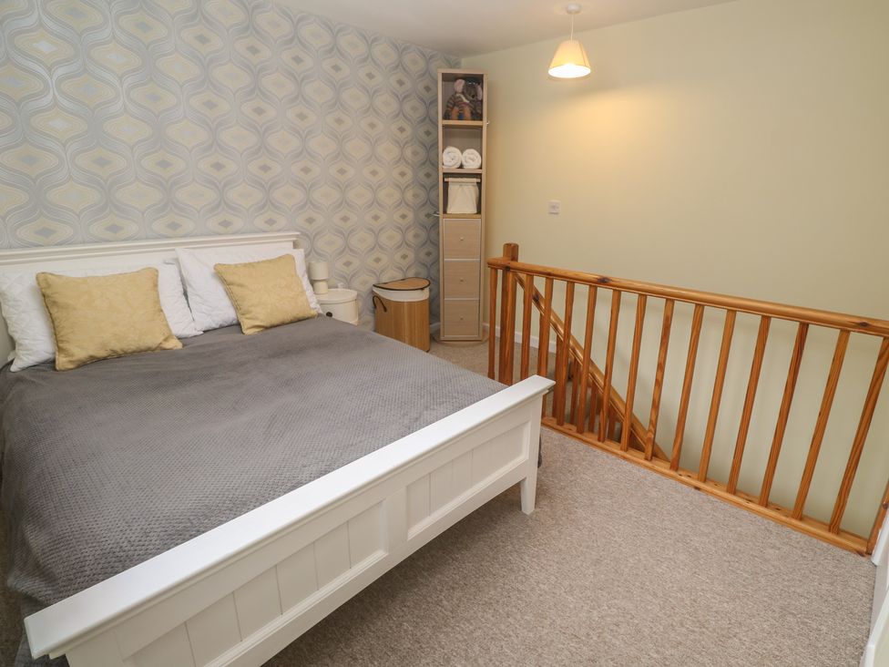 A bedroom with a bed and storage unit at Mini Mena in St Austell