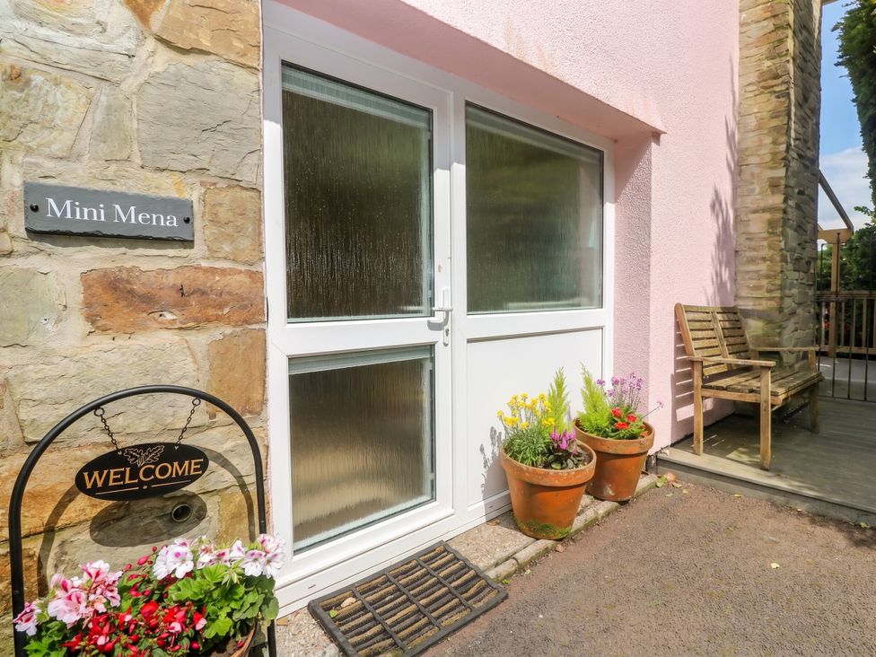 An outdoor entrance with a door and flower pots at Mini Mena in St Austell