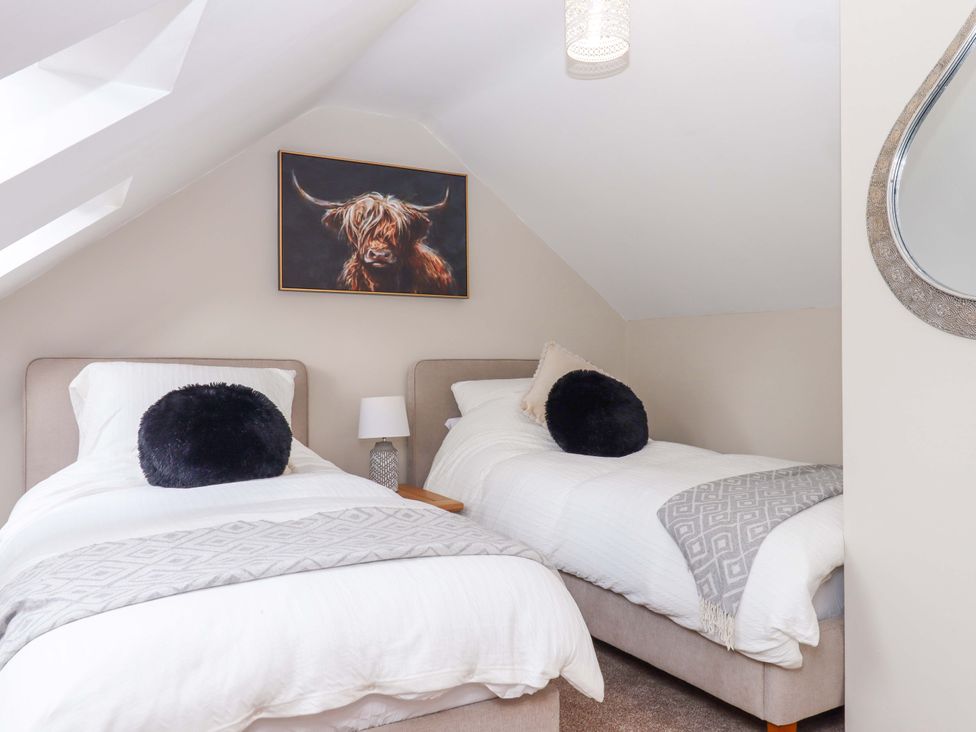 A bedroom with two beds and a painting at Church Barn Sutcombe near Bradworthy