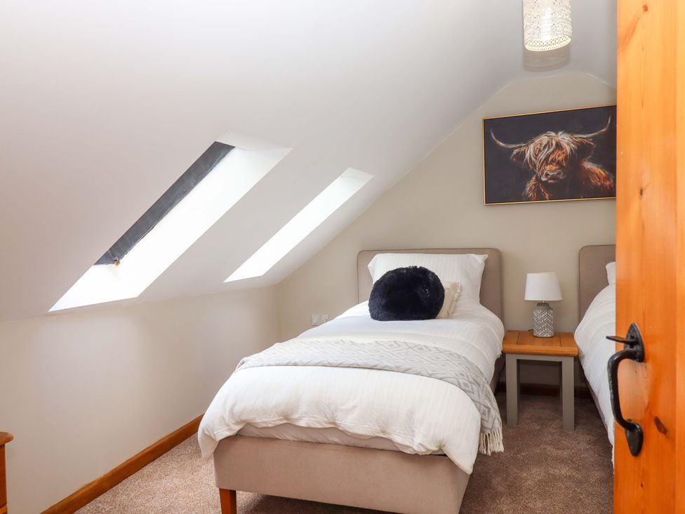A bedroom with two beds and a painting at Church Barn in Sutcombe near Bradworthy