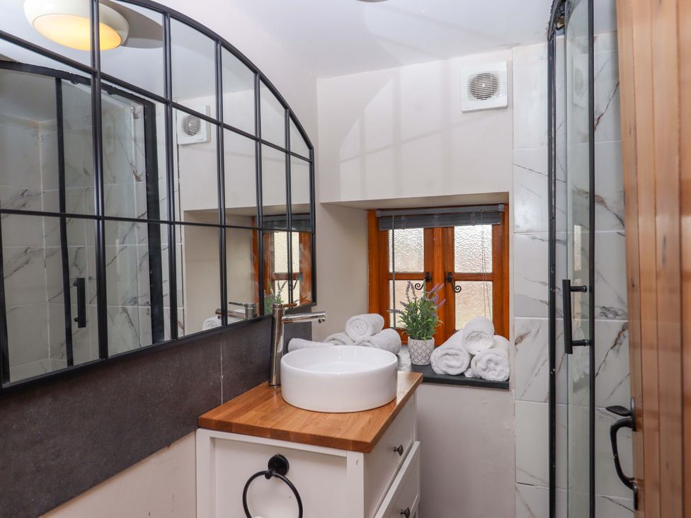 A bathroom with a sink and towels at Church Barn in Sutcombe near Bradworthy