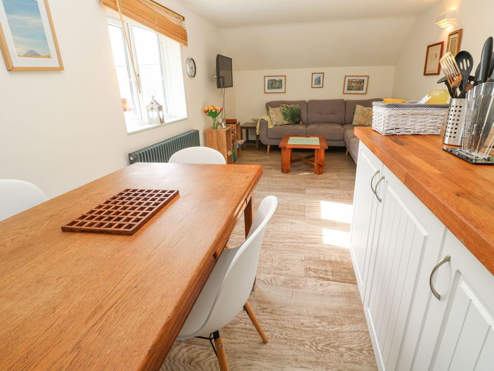 A dining area and living space with a sofa at Five Elements Barn in Truro