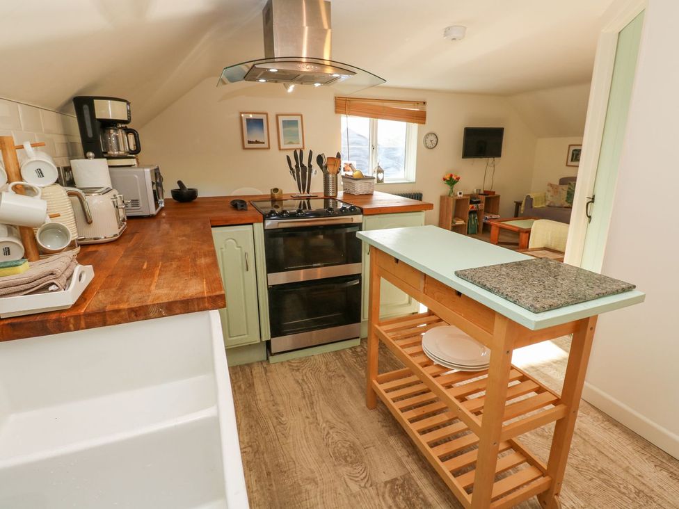 A kitchen with a stove, sink, and kitchen island at Five Elements Barn in Truro