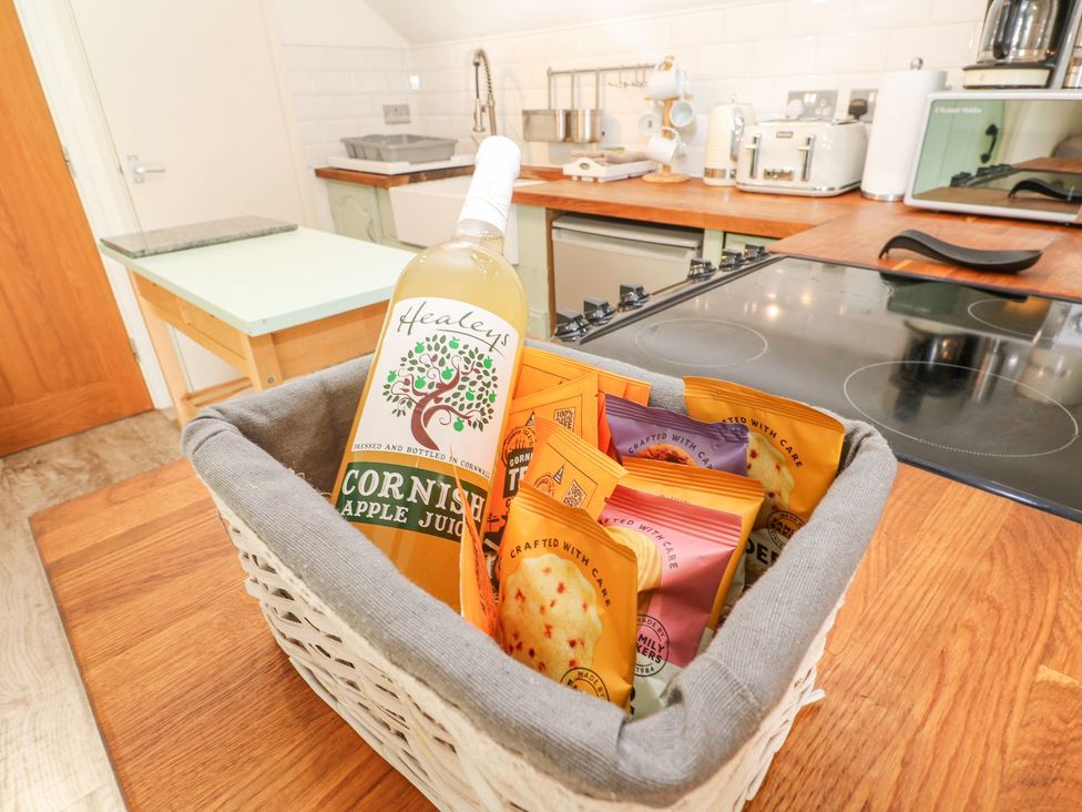 A bottle of apple juice and snacks in a basket on a kitchen countertop at Five Elements Barn Truro