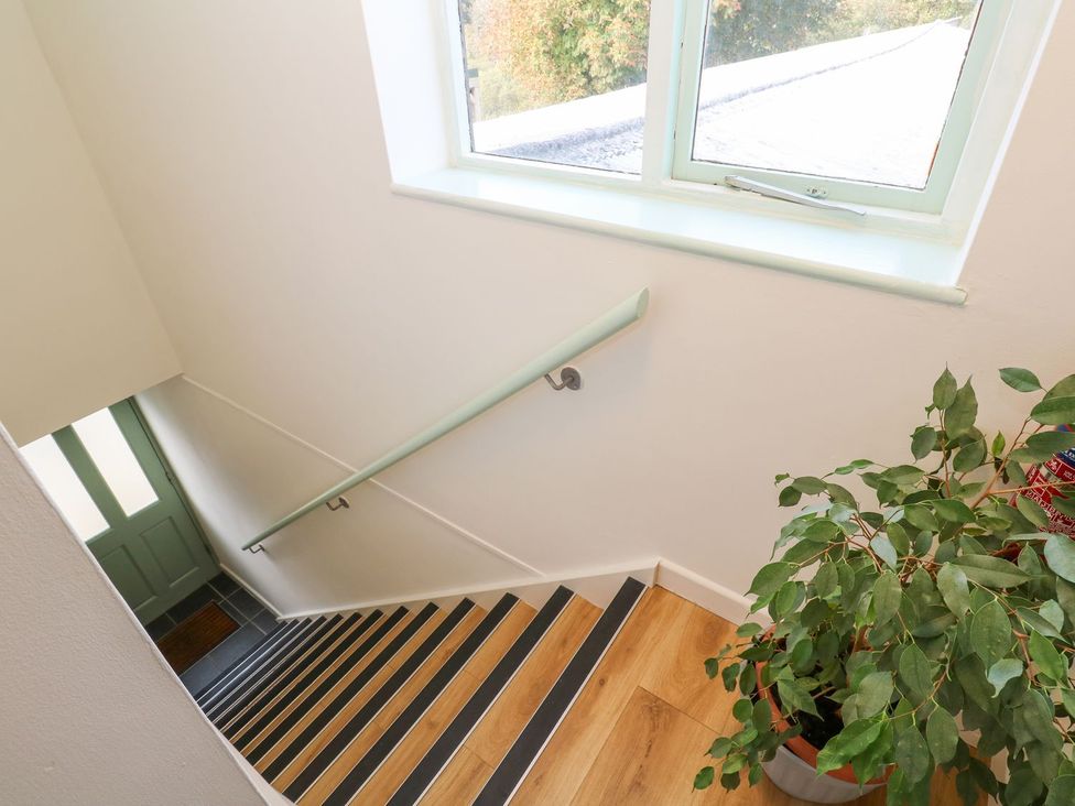 A stairway with a window and a plant at Five Elements Barn, Truro