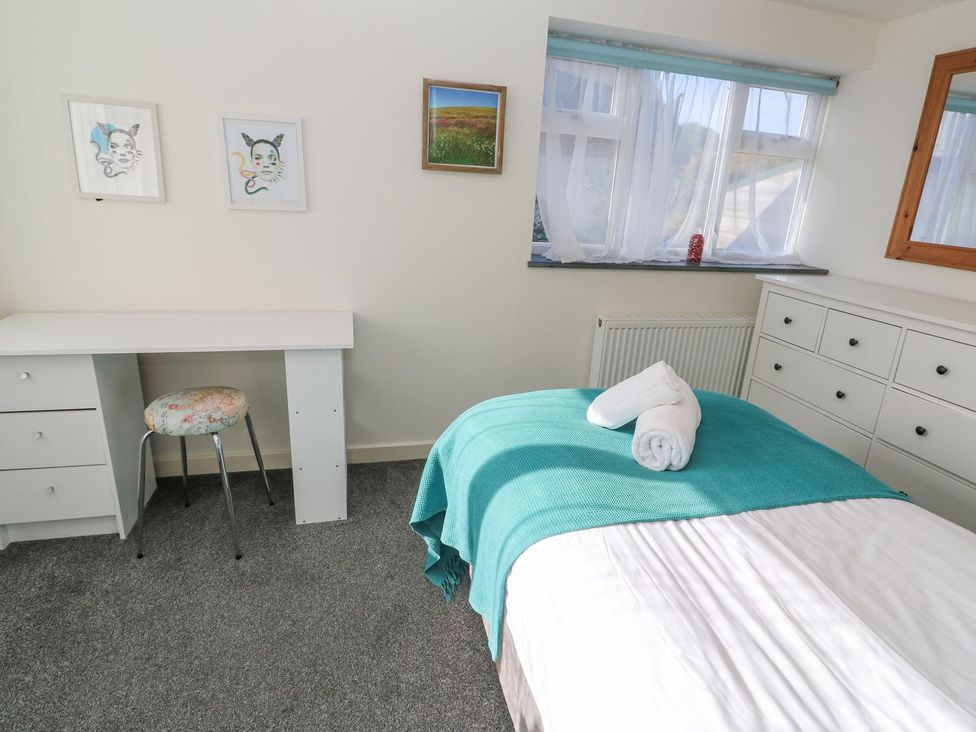 A bedroom with a bed and desk at Five Elements Barn Truro