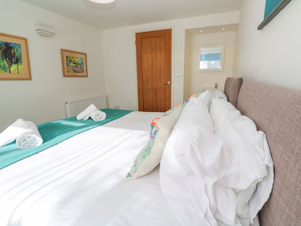 A bedroom with a bed and framed paintings at Five Elements Barn in Truro