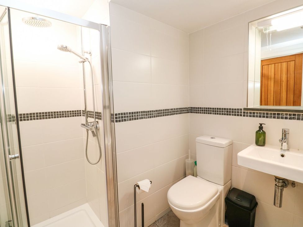 A bathroom with a shower, toilet, and sink at Five Elements Barn in Truro