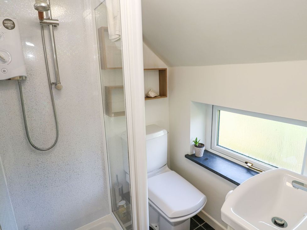 A bathroom with a shower, toilet, and sink at Five Elements Barn in Truro