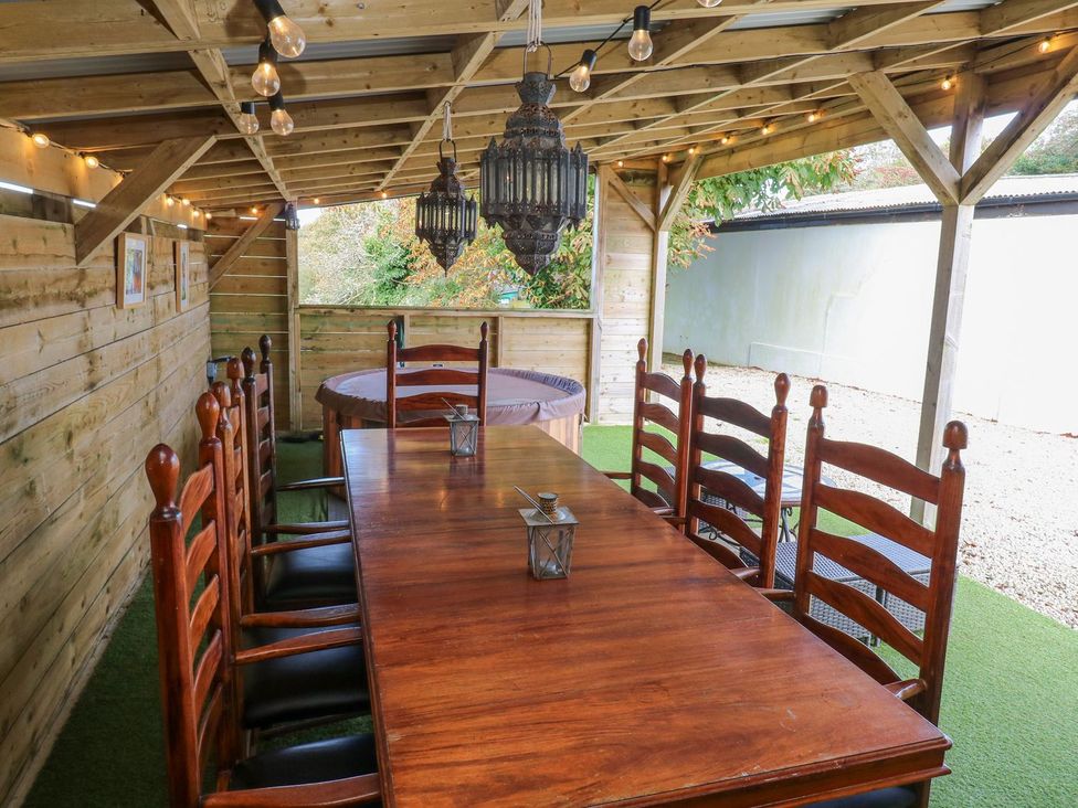 An outdoor dining area with a table and chairs at Five Elements Barn, Truro