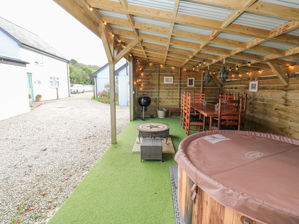 An outdoor seating area with a hot tub and dining table at Five Elements Barn in Truro