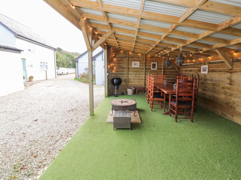 An outdoor seating area with a table and chairs at Five Elements Barn in St Agnes