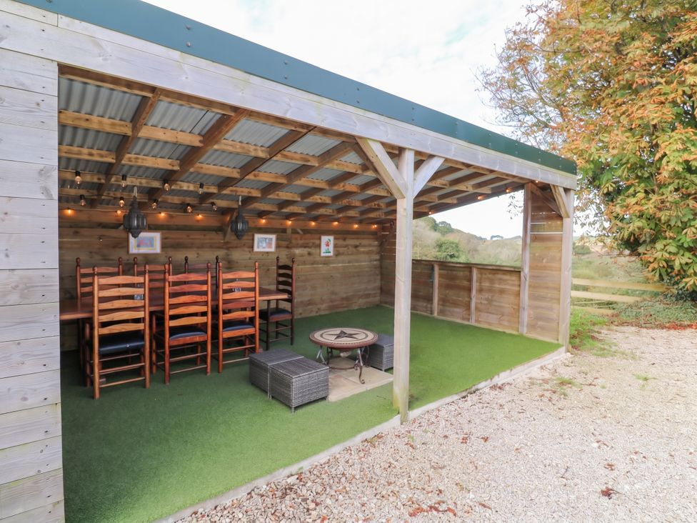 An outdoor dining area with tables and chairs at Five Elements Barn, St Agnes