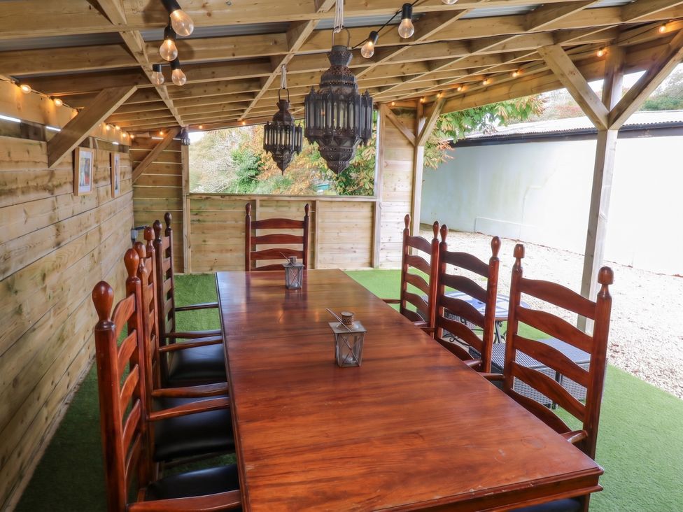 An outdoor dining area with a table and chairs at Five Elements Barn in St Agnes