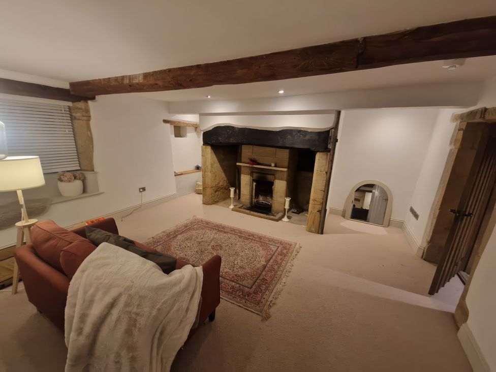 A living room with a fireplace and a sofa at 46 North Street, Stoke-Sub-Hamdon, Somerset