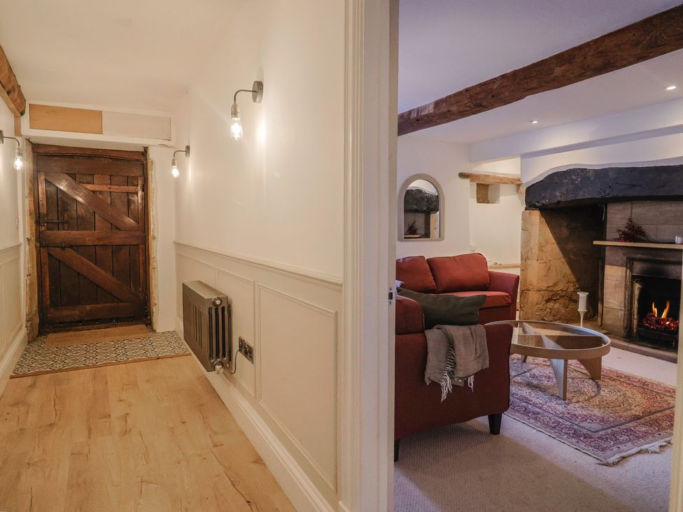 A hallway with a wooden door and access to a living room at 46 North Street Stoke-Sub-Hamdon, Somerset