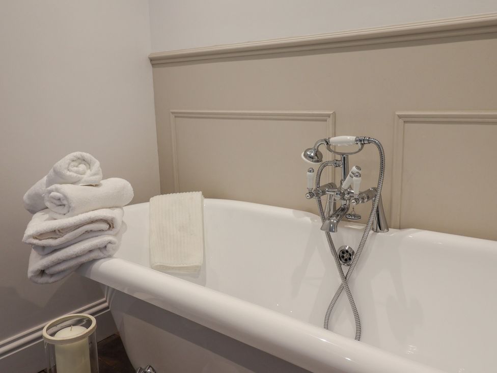 A bathtub with towels and a faucet at 46 North Street in Stoke-Sub-Hamdon, Somerset