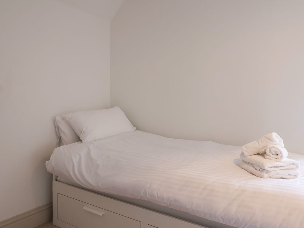 A bedroom with a bed and towels folded on top at 46 North Street Stoke-Sub-Hamdon, Somerset