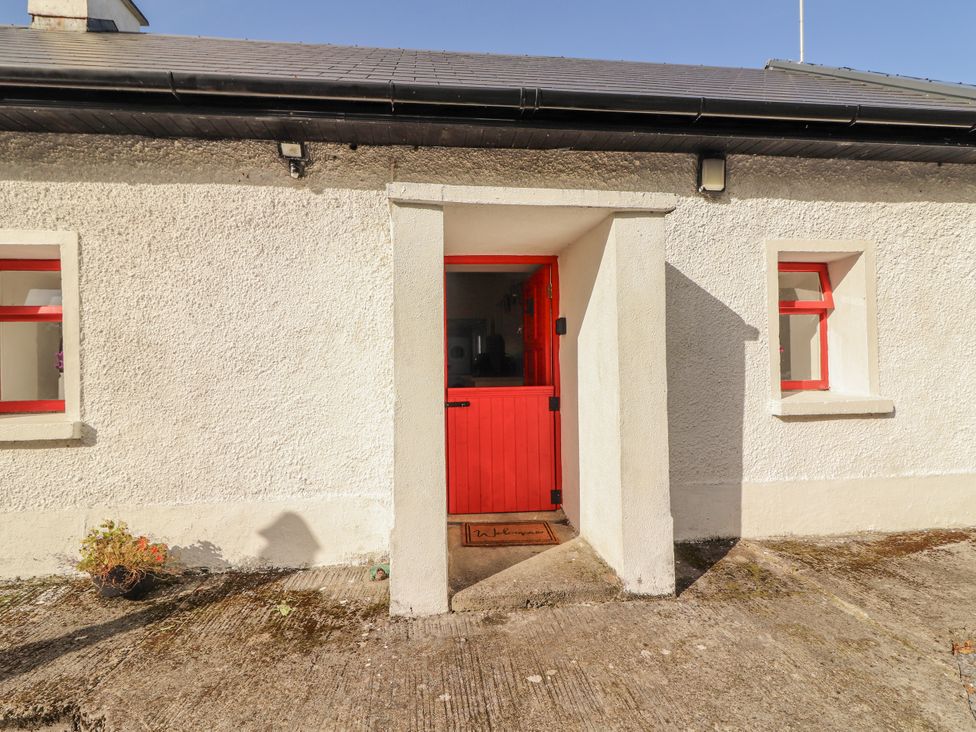 An entryway with a red door and windows at Kate's Cottage