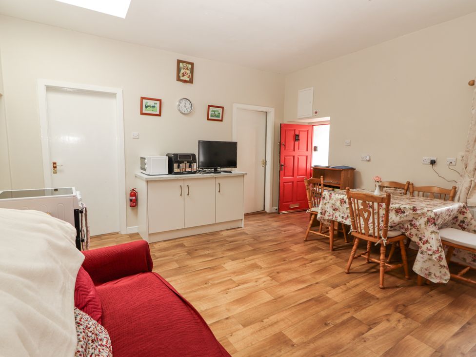 A living room with a table and chairs at Kate's Cottage
