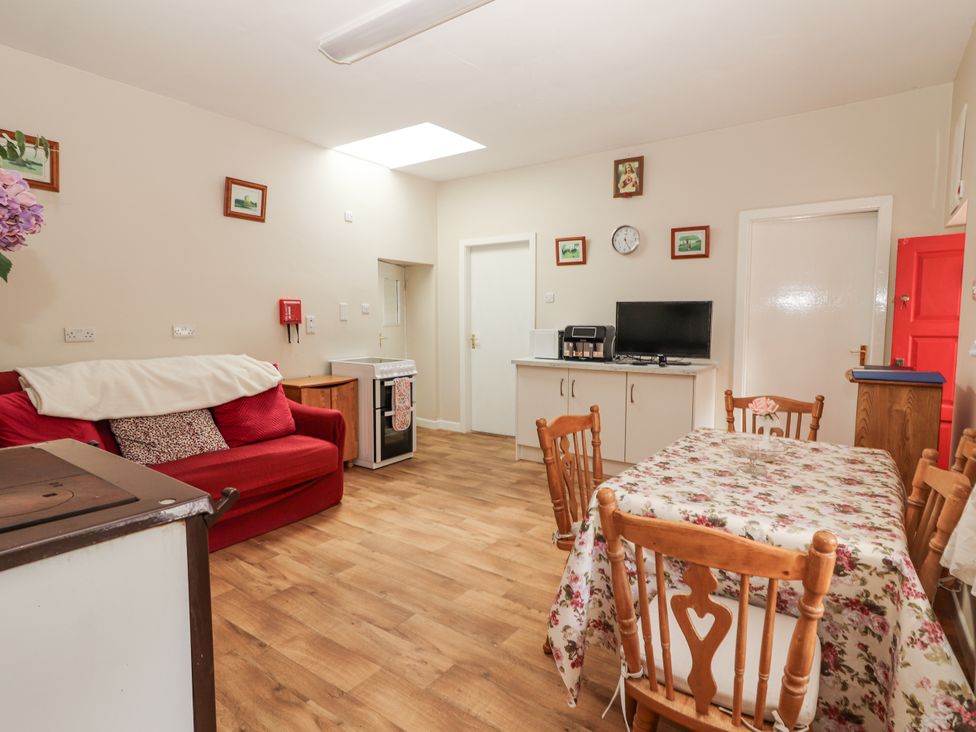 A kitchen with a table and chairs and a sofa at Kate's Cottage