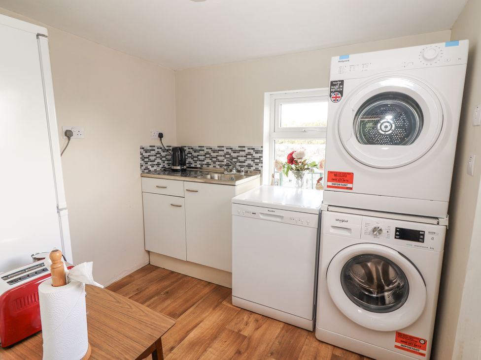 A laundry room with a washing machine and dryer at Kate's Cottage