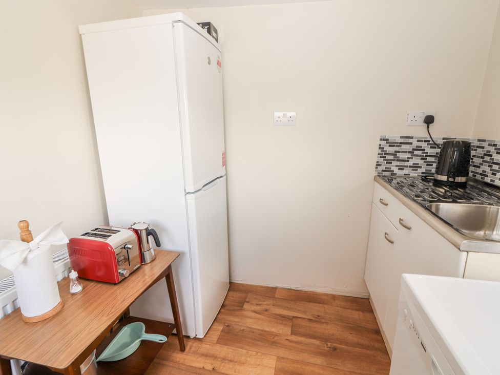 A kitchen with a refrigerator, toaster, and sink at Kate's Cottage