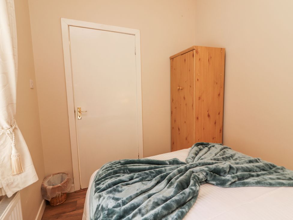 A bedroom with a bed and wardrobe at Kate's Cottage