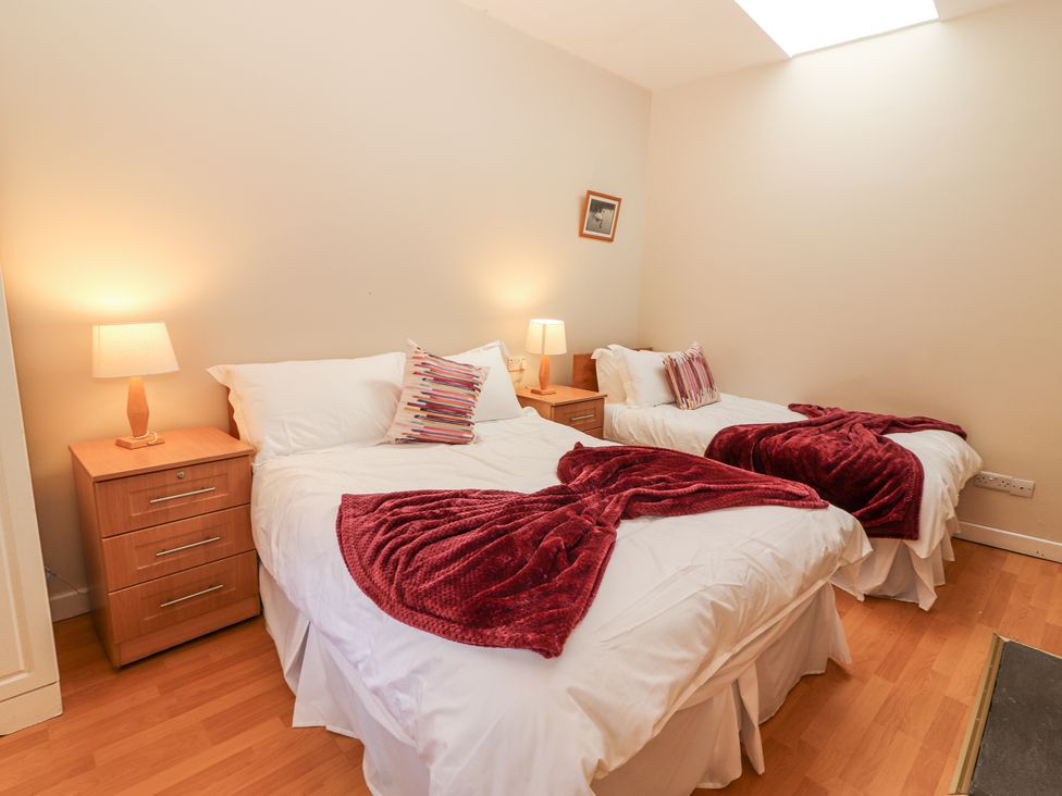 A bedroom with two beds and nightstands at Kate's Cottage