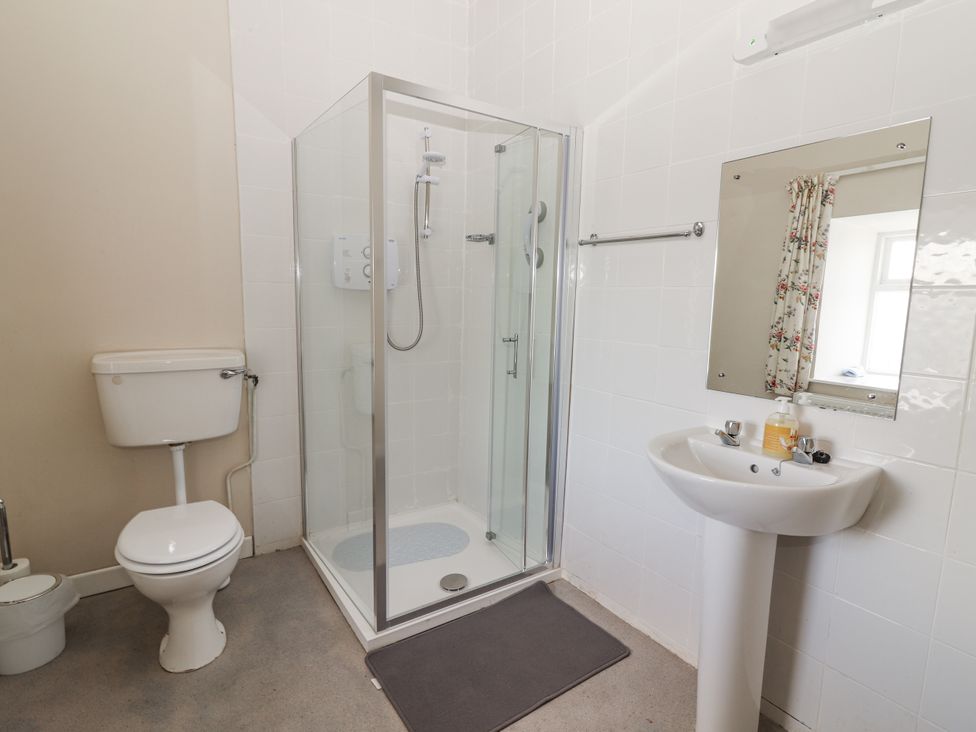 A bathroom with a shower, toilet, and sink at Kate's Cottage