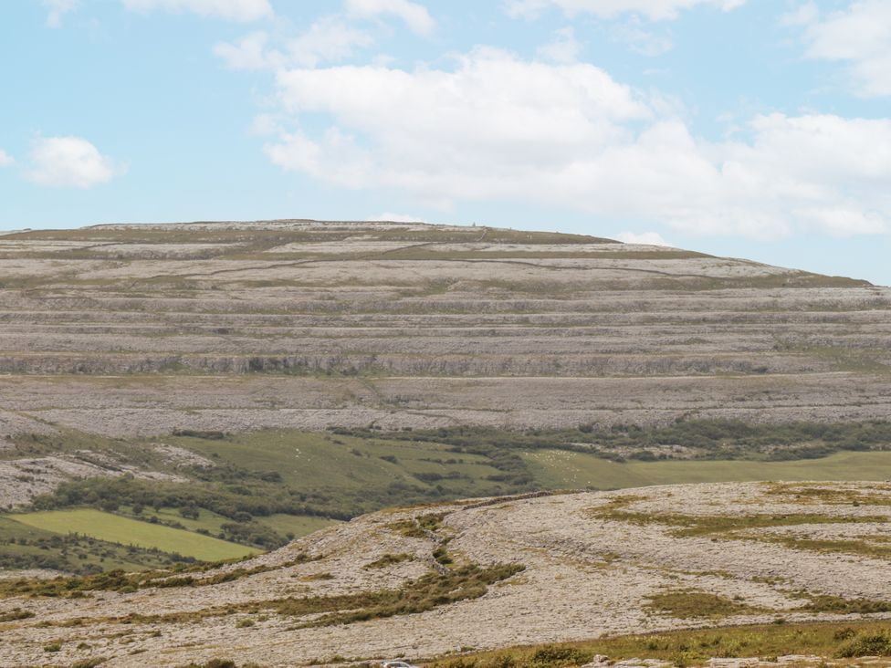 A landscape with hills and rocky surface under a blue sky at Kate's Cottage 