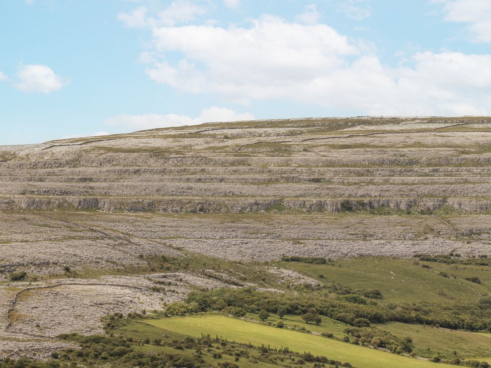 Landscape with hills and rock formations under a cloudy sky at Kate's Cottage