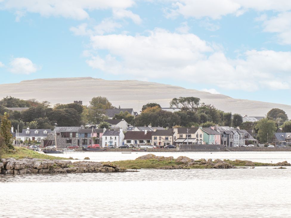 A view of houses along the water with a mountain in the background at Kate's Cottage