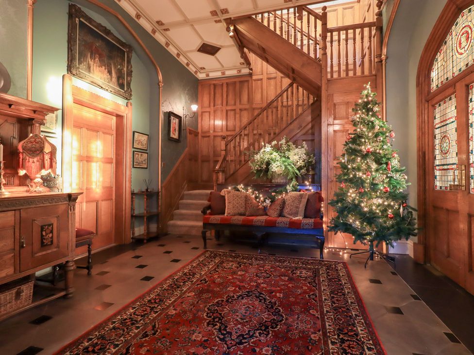 A foyer with a staircase and Christmas tree at Summerlands Hall Apartment