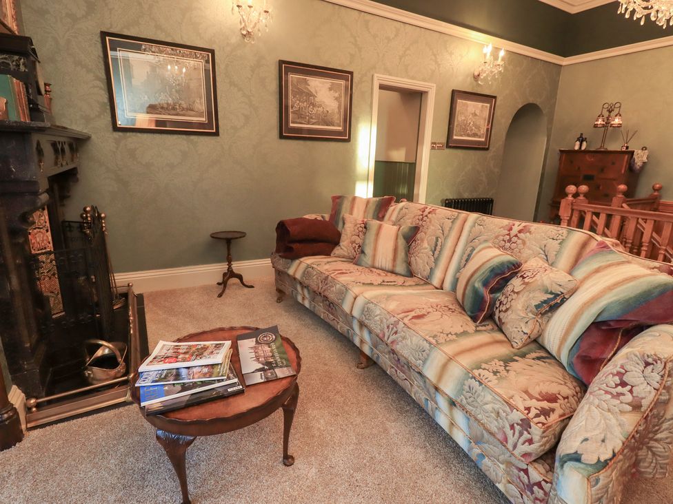 A living room with a sofa and table at Summerlands Hall Apartment