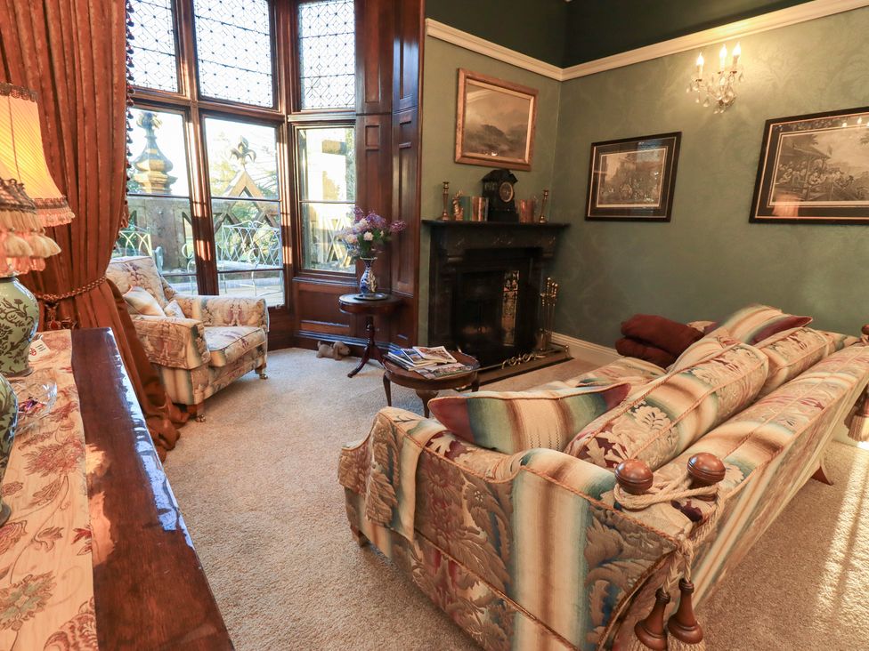 A living room with a sofa and lamp at Summerlands Hall Apartment