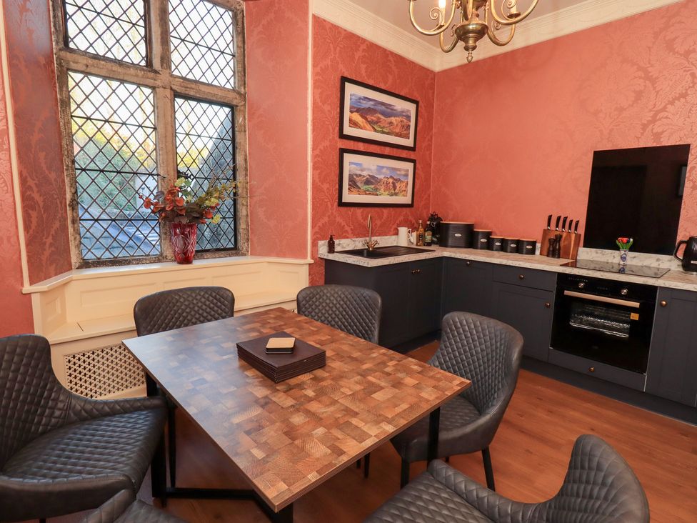 A kitchen with a table and chairs at Summerlands Hall Apartment