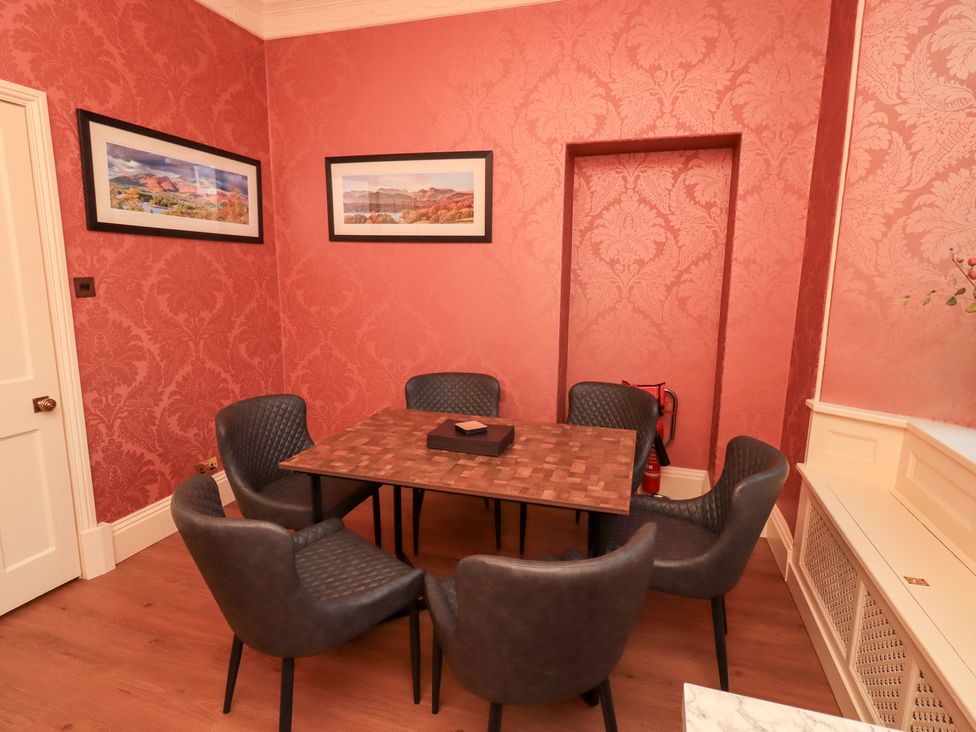 A dining room with a table and chairs at Summerlands Hall Apartment