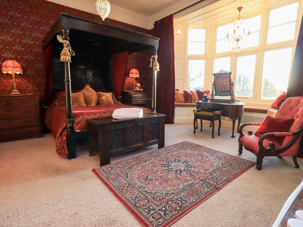 A bedroom with a canopy bed and window seating at Summerlands Hall Apartment