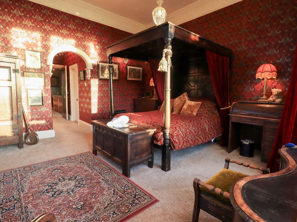 A bedroom with a four-poster bed and a dressing table at Summerlands Hall Apartment