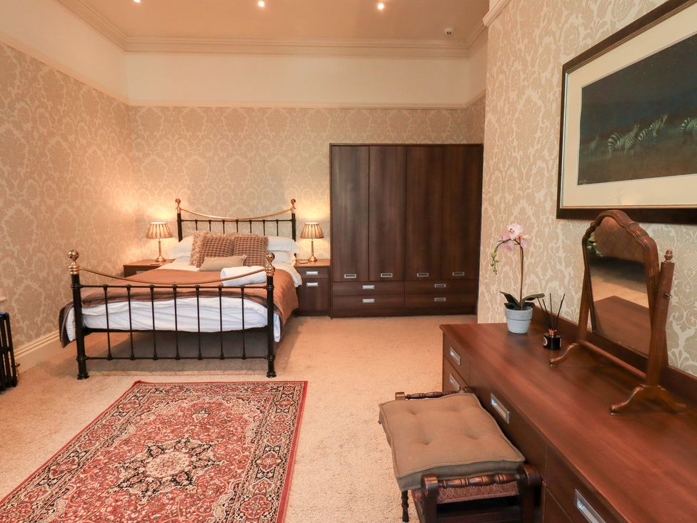 A bedroom with a bed and dressing table at Summerlands Hall Apartment