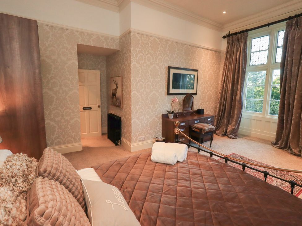 A bedroom with a bed and desk at Summerlands Hall Apartment