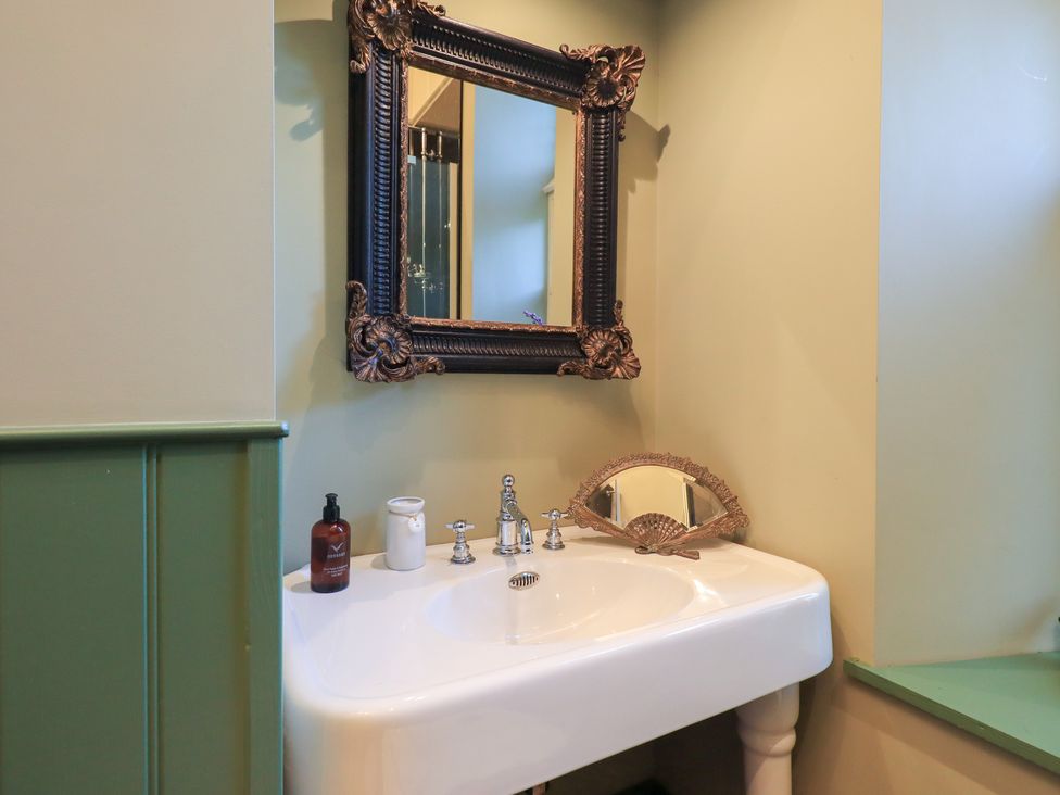 A sink with a decorative mirror at Summerlands Hall Apartment