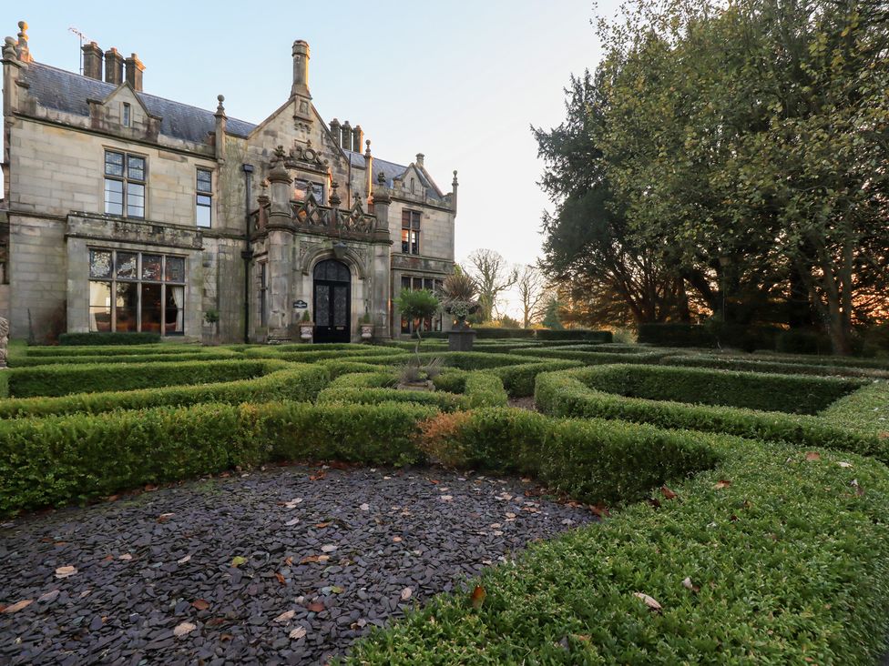 A garden with hedges and pathways at Summerlands Hall Apartment