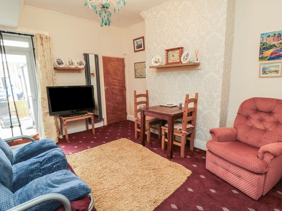 A living room with a sofa, armchair, and dining table at 170 Victoria Road