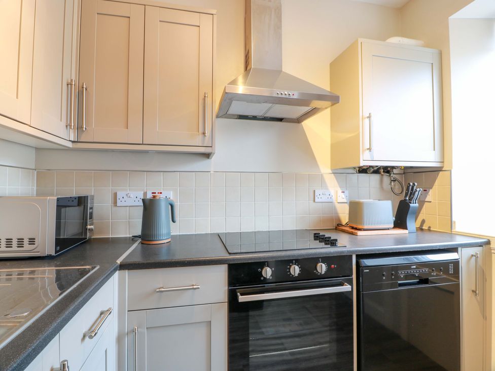 A kitchen with a microwave, kettle, cooker and dishwasher at Secret Garden @ 7