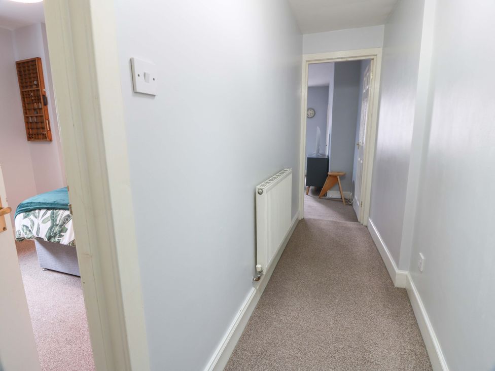 A hallway with a radiator and doorways at Secret Garden @ 7