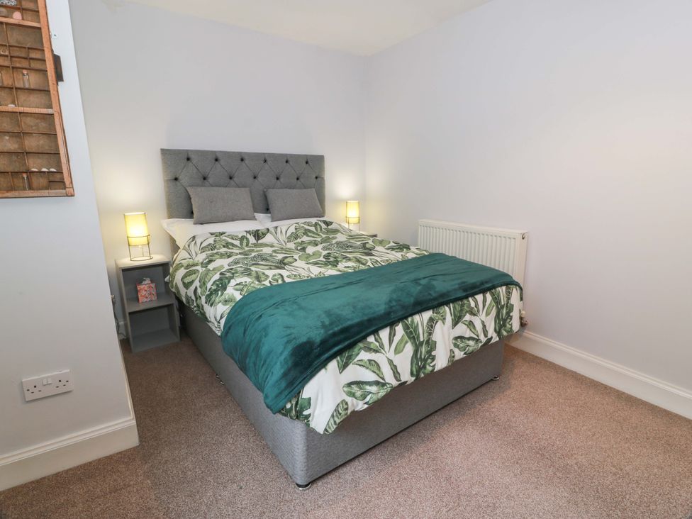 A bedroom with a bed and nightstands at Secret Garden @ 7